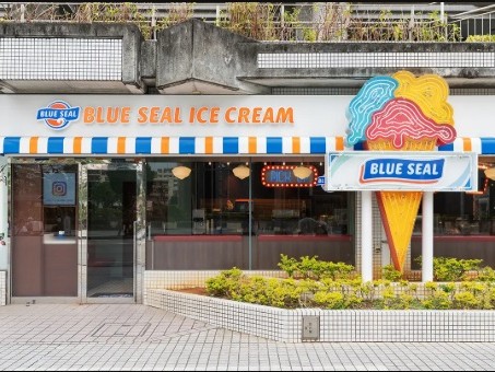 BLUE SEALパレットくもじ店の外観。青とオレンジのストライプの日よけと大きなアイスクリームの看板